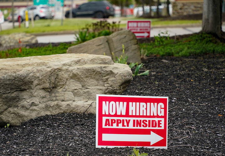 Hiring signs are posted outside a gas station in Cranberry Township, Pa., on May 5.