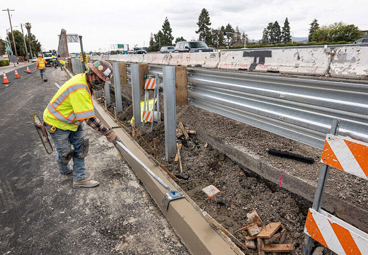 A contractor works on a road under repair along Highway 101 in San Mateo, Calif., in March.